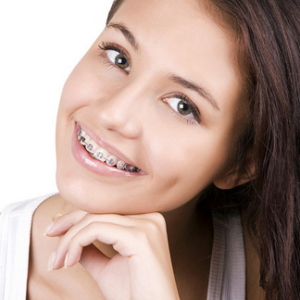 Headshot of girl with dark hair smiling with braces.